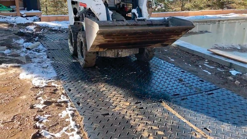 HDPE ground protection mats laid as a temporary access road for a tracked skid-steer loader